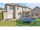 Large backyard featuring a trampoline, covered patio, and lush green lawn, perfect for outdoor activities at 4922 Summer Wind Dr, Buford, GA 30519