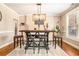 A contemporary dining room features a wooden bar table set on a white rug with a modern chandelier at 4922 Summer Wind Dr, Buford, GA 30519