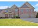 Stately two-story brick home featuring a two-car garage and well-manicured lawn at 4922 Summer Wind Dr, Buford, GA 30519