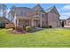 Charming two-story brick home featuring a covered front porch and lush landscaping at 4922 Summer Wind Dr, Buford, GA 30519