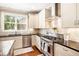Modern kitchen with stainless steel appliances, granite countertops, and white cabinets at 4922 Summer Wind Dr, Buford, GA 30519