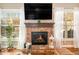 A living room features a brick fireplace with a dark mantel and hearth and two large windows with white curtains at 4922 Summer Wind Dr, Buford, GA 30519