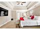 Spacious main bedroom with trey ceiling, ceiling fan, carpeted floor, and a large, upholstered headboard at 4922 Summer Wind Dr, Buford, GA 30519