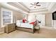 The primary bedroom features neutral paint, tray ceiling, carpet, and a tufted headboard with windows at 4922 Summer Wind Dr, Buford, GA 30519