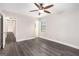 Open bedroom with ceiling fan, hardwood-style floors, and doorways to hallway and bathroom at 5700 Tracy Dr, Mableton, GA 30126