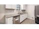 Updated kitchen with white cabinets, stone countertops, tile backsplash, and stainless steel dishwasher at 5700 Tracy Dr, Mableton, GA 30126