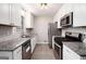 Modern kitchen featuring stainless steel appliances, granite countertops, white cabinets, and stylish backsplash at 5700 Tracy Dr, Mableton, GA 30126