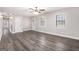 Bright living room featuring gray wood flooring, white trim, multiple windows, and a modern ceiling fan at 5700 Tracy Dr, Mableton, GA 30126