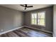 This bedroom features wood flooring, a ceiling fan, and a window view at 1504 Kimberly Pl, Canton, GA 30114