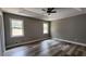 Large bedroom with tray ceilings, wood flooring, and ample natural light from the windows at 1504 Kimberly Pl, Canton, GA 30114