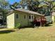 The backyard features a well-maintained lawn, a red deck, and mature trees offering shade and privacy at 2514 Green Forest Ct, Snellville, GA 30078