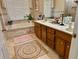 Spacious bathroom with double sink vanity, tile flooring, jacuzzi tub and tiled walls at 2514 Green Forest Ct, Snellville, GA 30078