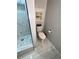 Bathroom with a toilet, tile floors, shower stall with glass door, neutral walls and a window at 2514 Green Forest Ct, Snellville, GA 30078
