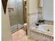 Elegant bathroom featuring a tiled soaking tub, glass shower with tile surround, and a neutral color palette at 2514 Green Forest Ct, Snellville, GA 30078