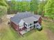 Aerial view of the backyard featuring a spacious brick home, deck, and lush lawn in a private setting at 270 Morrow Rd, Newborn, GA 30056