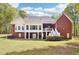 Backyard featuring a sunroom, a walkout basement, a lush green lawn, and many trees surrounding the property at 270 Morrow Rd, Newborn, GA 30056