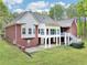 Expansive backyard featuring a brick home with a deck, patio, and lush green lawn, perfect for outdoor living at 270 Morrow Rd, Newborn, GA 30056