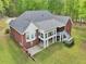 Backyard aerial view of a brick home with a spacious lawn, deck, and patio area, offering ample outdoor space at 270 Morrow Rd, Newborn, GA 30056