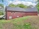 Rear view of brick home with large backyard featuring a well-maintained lawn and mature trees at 270 Morrow Rd, Newborn, GA 30056
