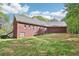 Rear view of a spacious brick home with a sloped lawn and surrounding trees, offering a private outdoor space at 270 Morrow Rd, Newborn, GA 30056