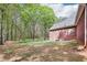 Large backyard with a brick house and lush green trees at 270 Morrow Rd, Newborn, GA 30056