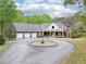 Charming brick home featuring a circular driveway and a spacious three-car garage, surrounded by lush trees at 270 Morrow Rd, Newborn, GA 30056