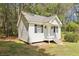Cozy cottage with white wood siding, black shutters, a porch, and landscaping at 270 Morrow Rd, Newborn, GA 30056