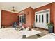 Inviting front porch with brick exterior, decorative door, ceiling fan, and comfortable seating area at 270 Morrow Rd, Newborn, GA 30056
