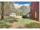 Expansive backyard featuring a cottage, brick house, and mature trees at 270 Morrow Rd, Newborn, GA 30056