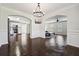 Spacious open-concept featuring dark wood floors, crown molding, and seamless access to other rooms at 3380 Duncan Bridge Dr, Buford, GA 30519