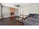 Cozy living room featuring a stone fireplace, dark wood floors, and a modern ceiling fan at 3380 Duncan Bridge Dr, Buford, GA 30519