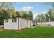Large, grassy backyard featuring white brick home with black trim and plenty of trees at 307 Gordon Woods Sw Dr, Mableton, GA 30126