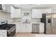 Updated kitchen features stainless appliances, white cabinets, marble countertops, and updated fixtures at 307 Gordon Woods Sw Dr, Mableton, GA 30126