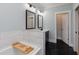 Inviting bathroom with soaking tub, herringbone tile floor, and doorway leading to other rooms at 3172 Chapel St, Scottdale, GA 30079