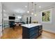 Open concept kitchen with an island flowing into a living space with a fireplace at 3172 Chapel St, Scottdale, GA 30079