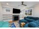 Bright living room with a modern fireplace, built-in shelves, ceiling fan and comfortable blue furniture at 3172 Chapel St, Scottdale, GA 30079