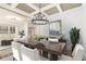 Elegant dining room showcasing a coffered ceiling, stylish chandelier, and large windows offering scenic views at 400 Stone Lea Trce, Oxford, GA 30054
