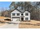 Modern two-story home with white siding, black trim, and attached garage on a sunny lot at 400 Stone Lea Trce, Oxford, GA 30054