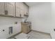 The laundry room has tile flooring, a utility sink, and upper cabinets for storage at 400 Stone Lea Trce, Oxford, GA 30054