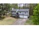 Two-story gray home with a two-car garage and well-maintained lawn with a driveway and basketball hoop at 175 W Station Nw Dr, Kennesaw, GA 30144