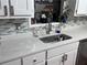 Close-up on a modern kitchen sink, featuring white quartz countertops and a gray backsplash for an elegant touch at 175 W Station Nw Dr, Kennesaw, GA 30144