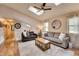 Bright living room with skylights, ceiling fan, hardwood floors, and large windows with decorative shades at 175 W Station Nw Dr, Kennesaw, GA 30144