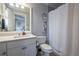 Well lit bathroom featuring vanity, toilet, shower with white shower curtain and modern fixtures at 225 Ansley Close, Roswell, GA 30075