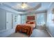 Comfortable bedroom featuring plush carpeting, natural light, and tray ceiling at 225 Ansley Close, Roswell, GA 30075
