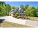 Spacious home featuring a long driveway, three car garage and manicured landscaping at 225 Ansley Close, Roswell, GA 30075