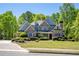Beautiful two-story brick home with lush landscaping and a well-manicured lawn on a sunny day at 225 Ansley Close, Roswell, GA 30075