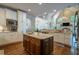 Spacious kitchen with an island, stainless steel appliances, white cabinets, and hardwood flooring at 225 Ansley Close, Roswell, GA 30075