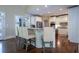 Spacious kitchen with hardwood floors, white cabinets, stainless appliances, and bar stool seating at 225 Ansley Close, Roswell, GA 30075