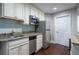 Basement kitchenette with white cabinets, granite countertops, stainless steel appliances and dark wood flooring at 225 Ansley Close, Roswell, GA 30075