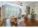 Bright living room with fireplace, ceiling fan, hardwood floors, and large windows overlooking trees at 225 Ansley Close, Roswell, GA 30075